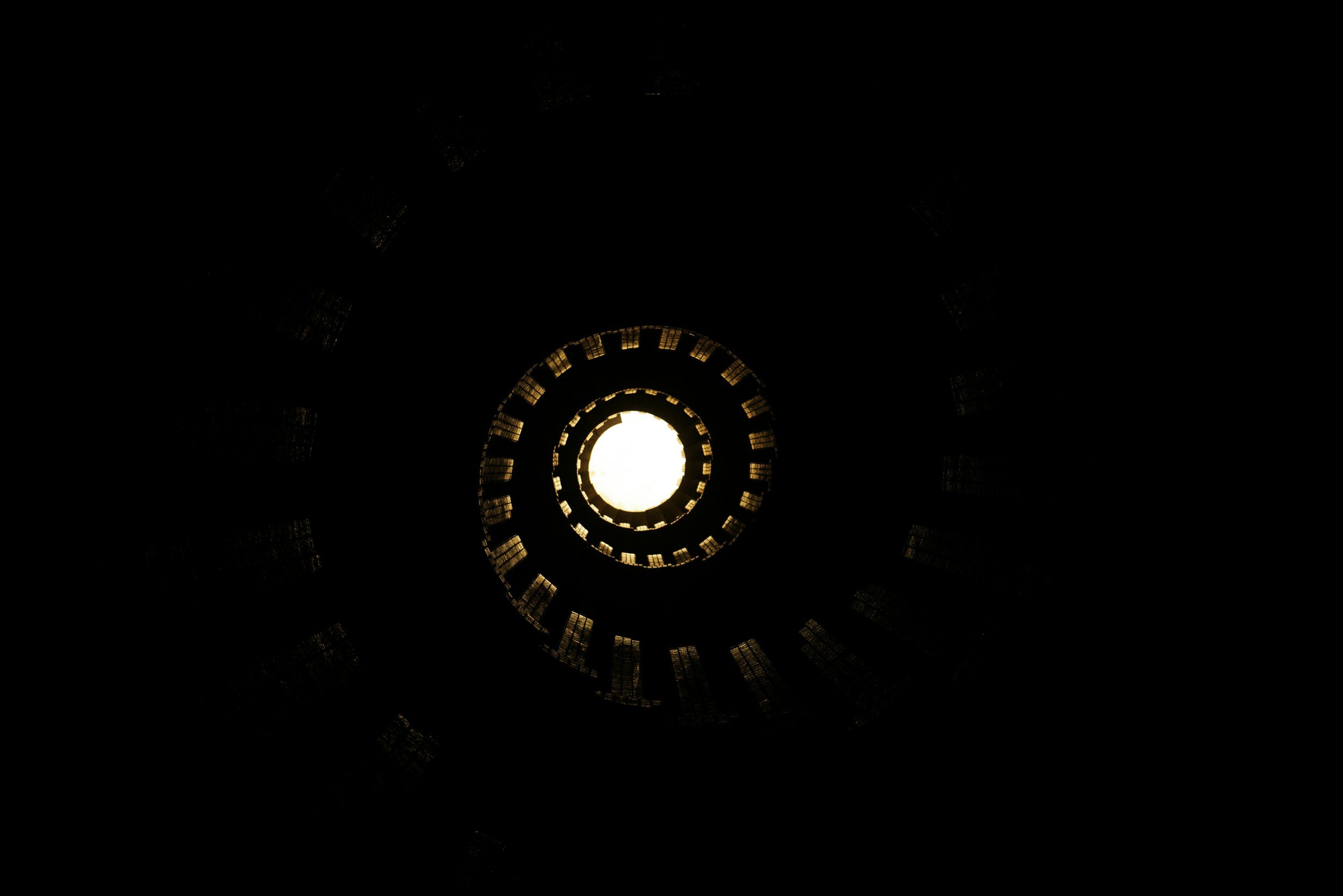 View looking up a spiral staircase with light at the top.